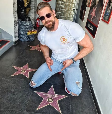 Olivier wearing a white t-shirt and a blue jeans.